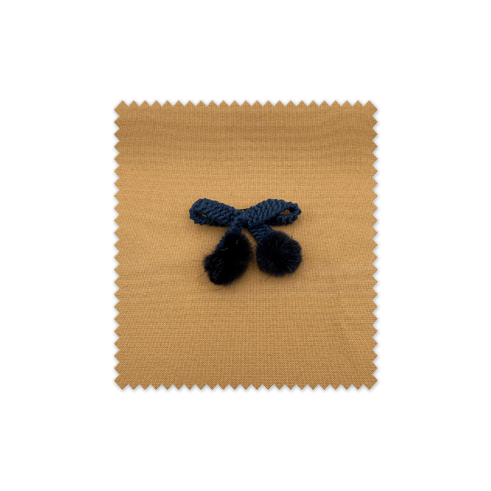 Lazo de ganchillo azul con pompones decorativos para manualidades y costura