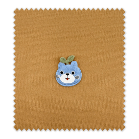 Detalle del parche manzana con cara azul bordado