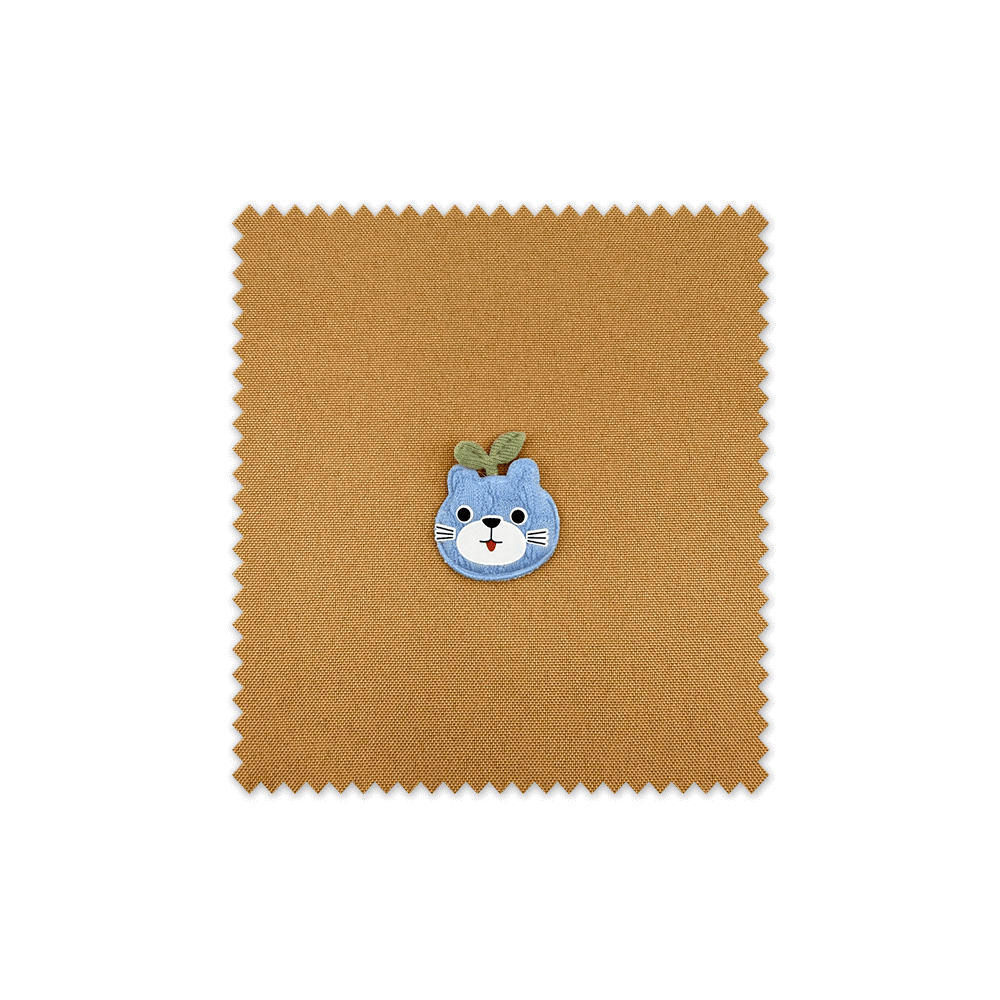 Detalle del parche manzana con cara azul bordado