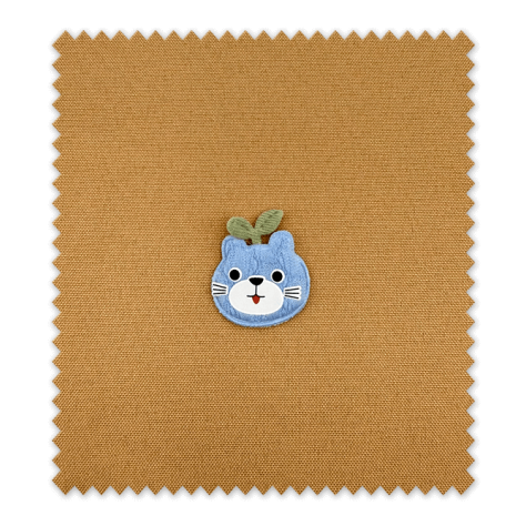 Detalle del parche manzana con cara azul bordado