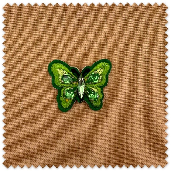 Mini aplique decorativo de mariposa verde con piedras ornamentales para personalizar prendas y complementos textiles.